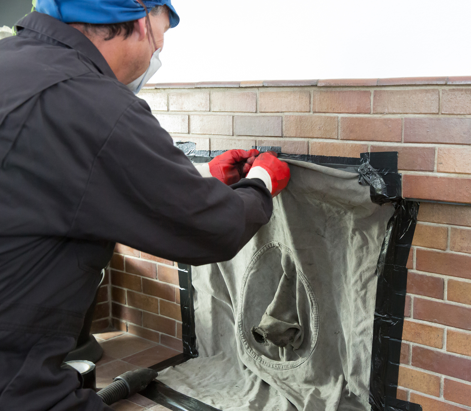 Chimney sweep wearing a mask cleaning chimney